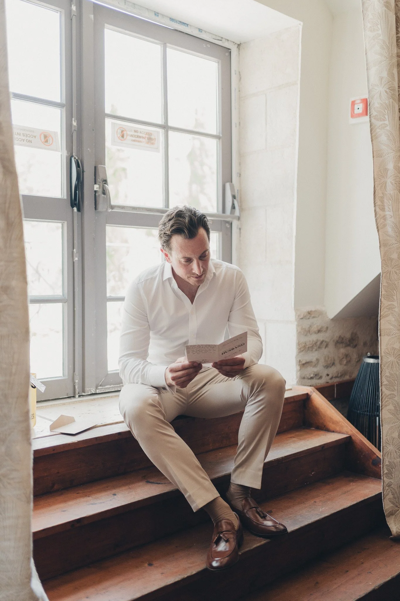 Groom reading a handwritten letter on the morning of the wedding.