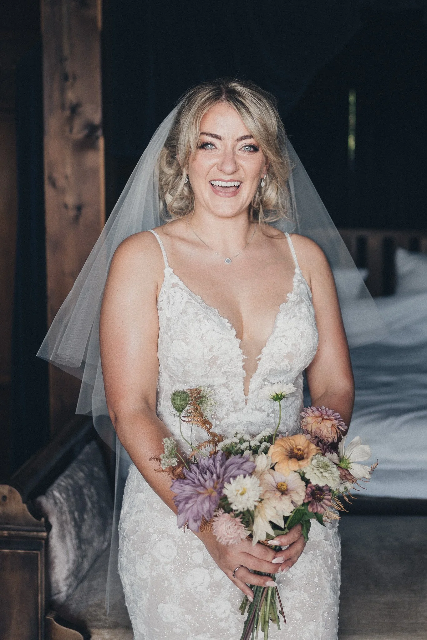 Bride smiling and holding her bouquet before walking to the ceremony.