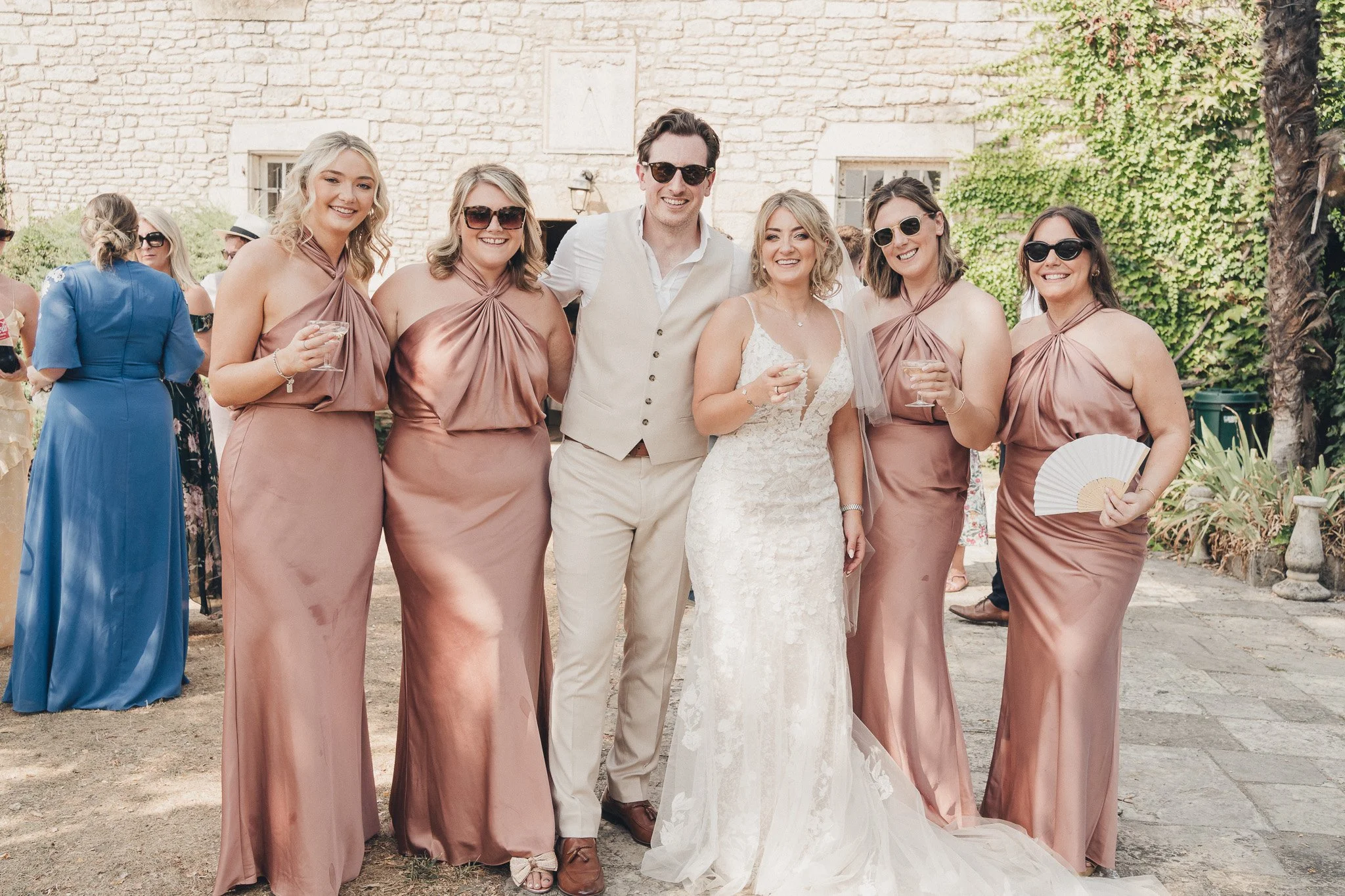Group photo of the couple with their bridesmaids during the outdoor reception