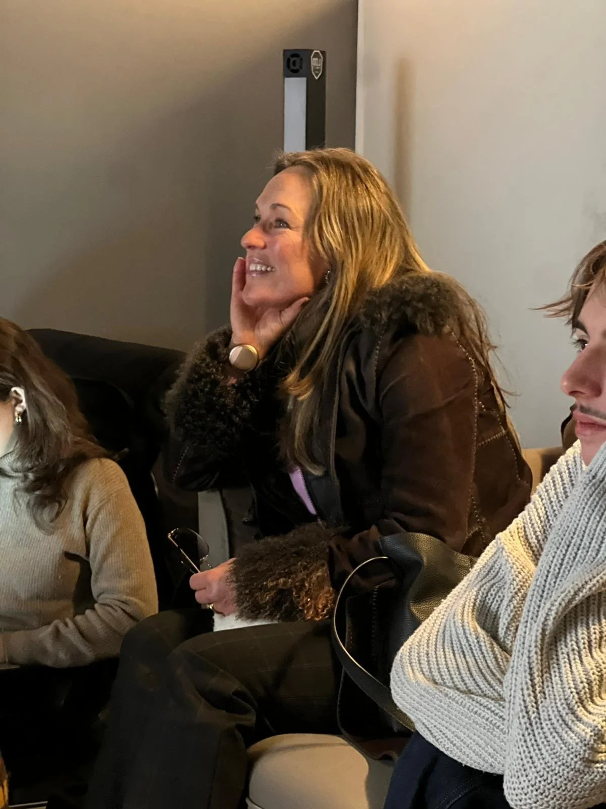Jess Kedward sitting and listening during a reading event for an upcoming project.