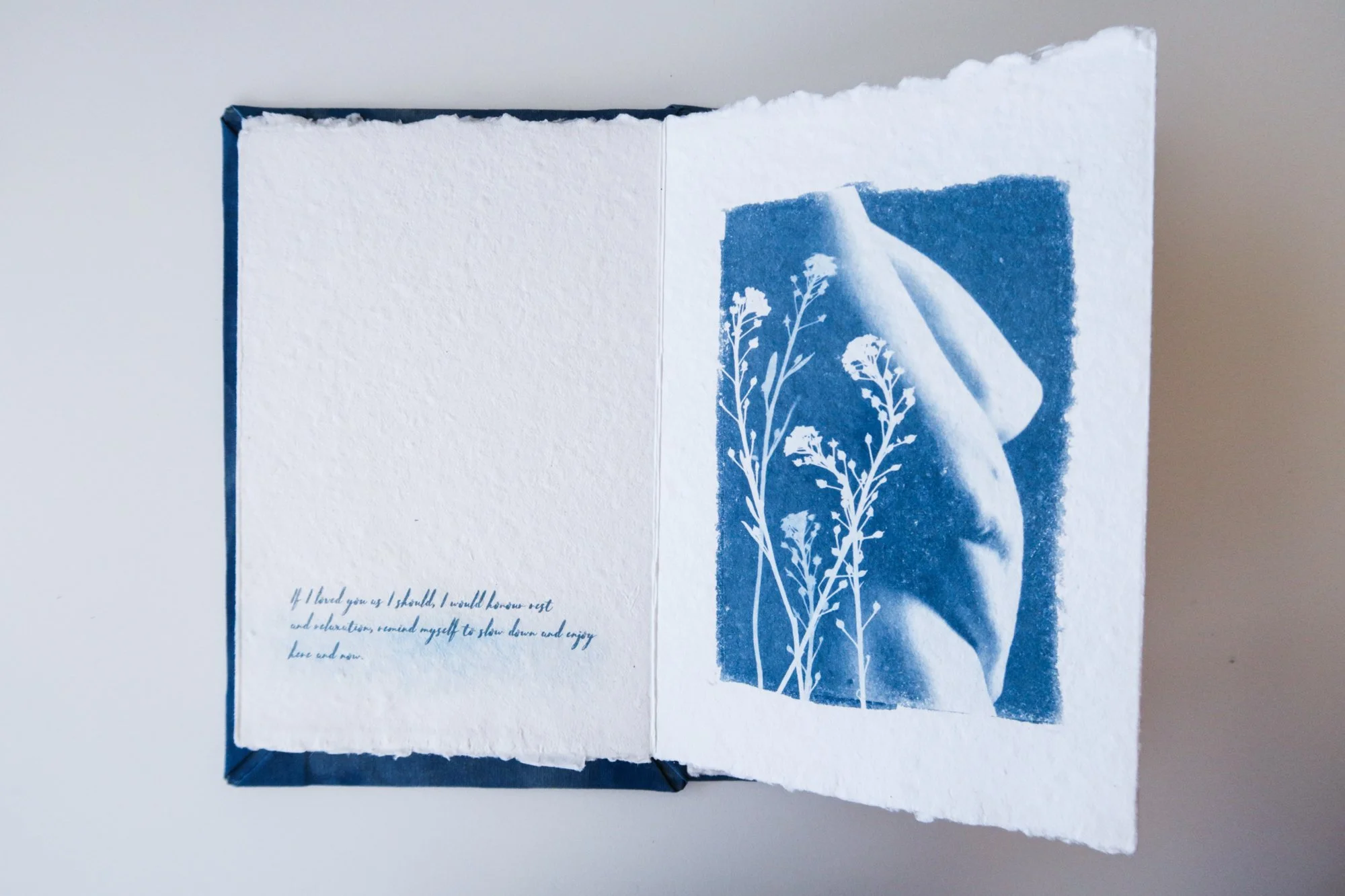 Page from a handmade artist book by Yanina Shevchenko, part of her project If I Loved You As I Should — a body-focused exploration of self-acceptance. Printed on handmade paper using cyanotype, the image combines body forms and natural elements