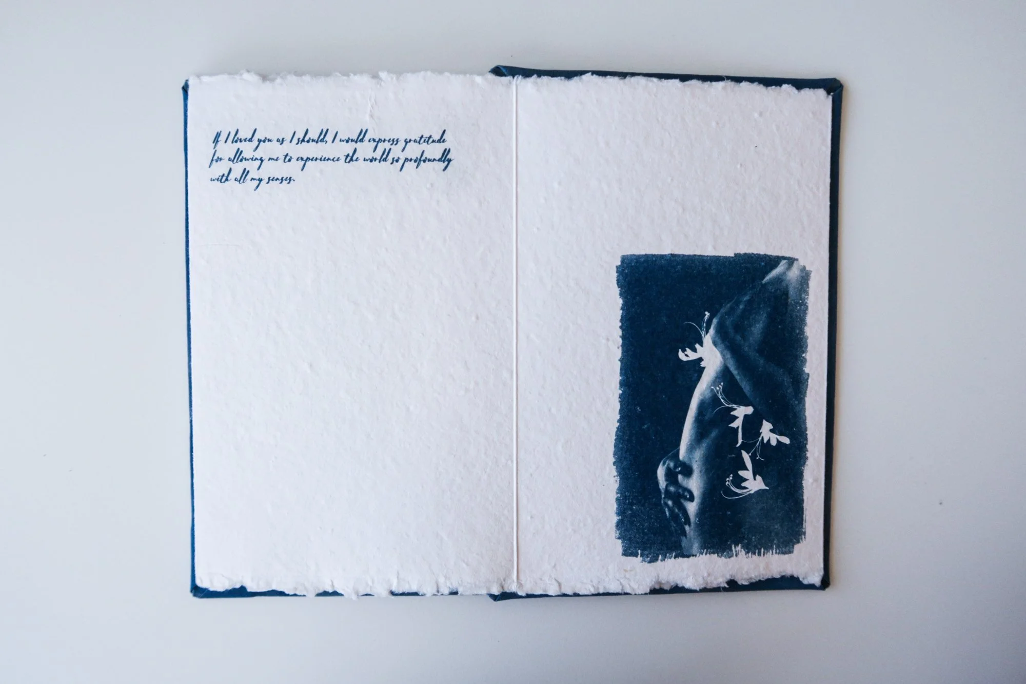 Page from a handmade artist book by Yanina Shevchenko, part of her project If I Loved You As I Should — a body-focused exploration of self-acceptance. Printed on handmade paper using cyanotype, the image combines body forms and natural elements