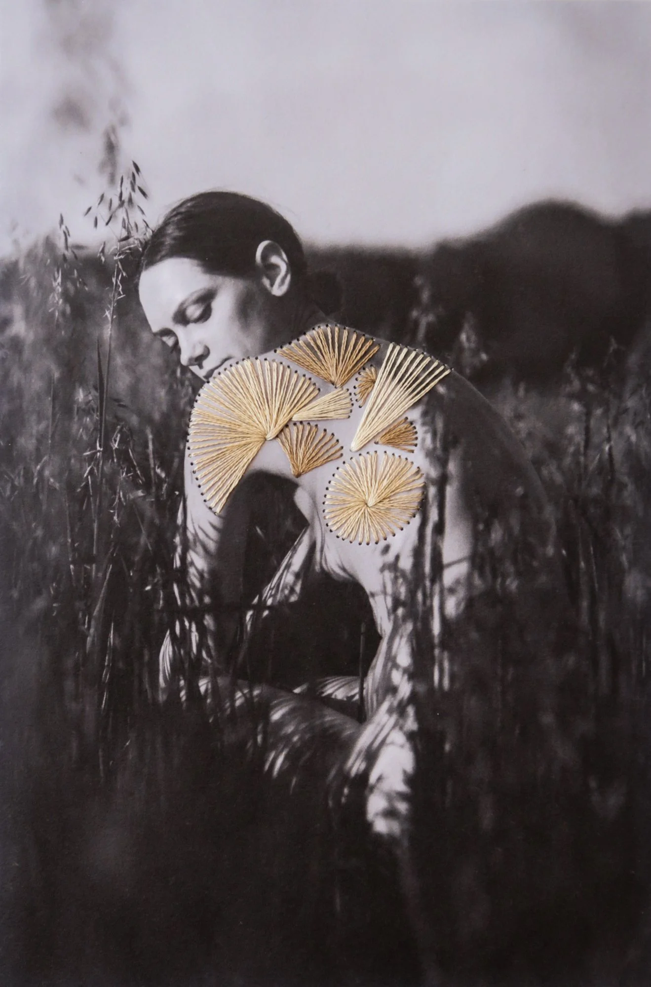 A photograph combining nude body, thread, and nature, photo embroidery on paper by Yanina Shevchenko, an artwork from her project We Are One