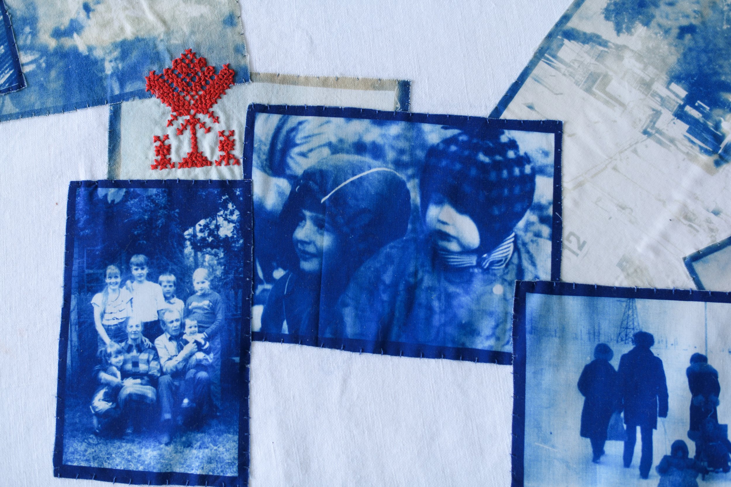 A collage of blue-tinted photographs, including a group of children and a woman wearing sunglasses, with a red embroidered design of a tree and other stitched elements on fabric.