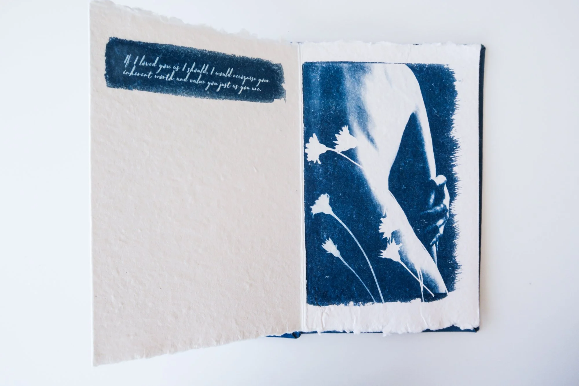 Page from a handmade artist book by Yanina Shevchenko, part of her project If I Loved You As I Should — a body-focused exploration of self-acceptance. Printed on handmade paper using cyanotype, the image combines body forms and natural elements