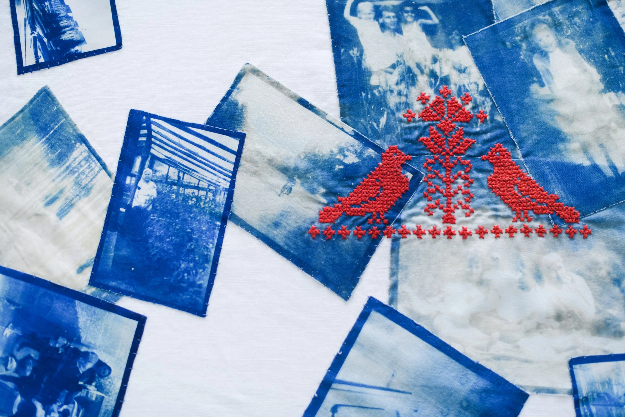 A collage of blue-tinted photographs featuring various people and scenes, with a red embroidered design of a Christmas tree and reindeer in the center.