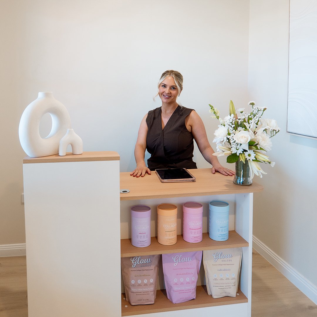 Photo of Letitia, owner of Letitia Aesthetics standing behind a clinic reception desk