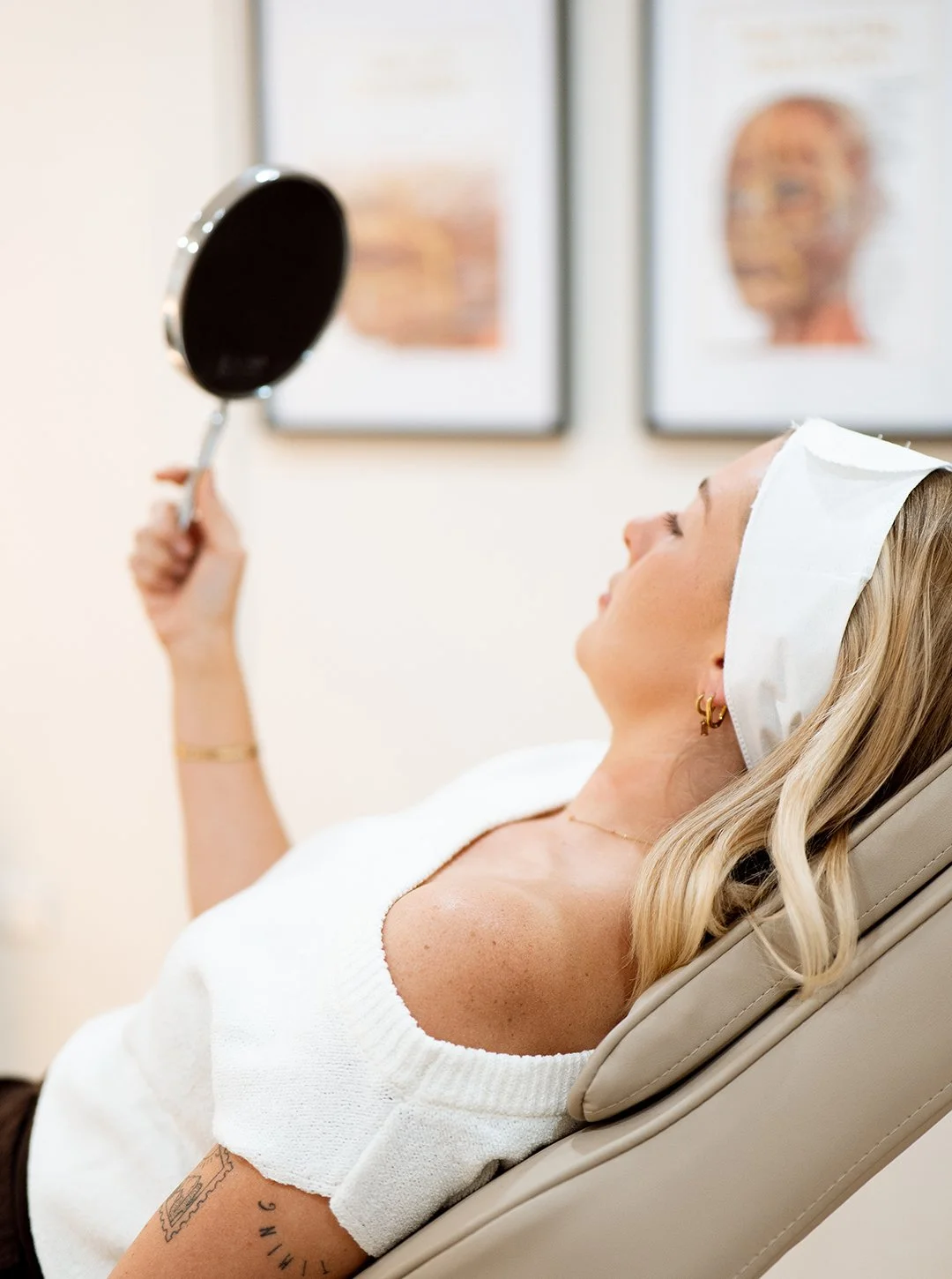 Photo of patient examining her skin in handheld mirror