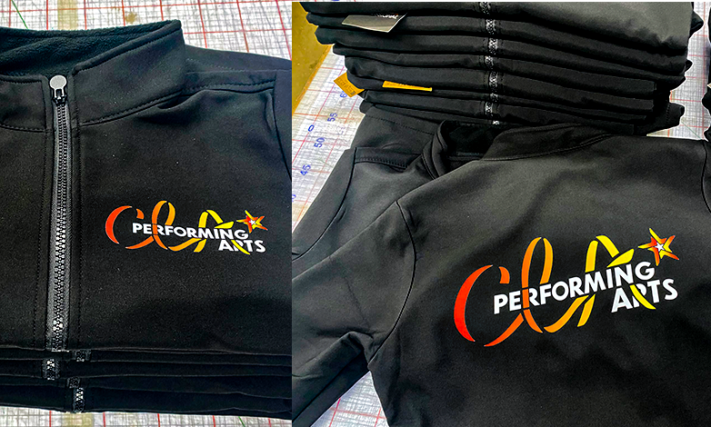 Close-up of black jackets with the Performing Arts logo, featuring stylized orange, yellow, and red text and a star.