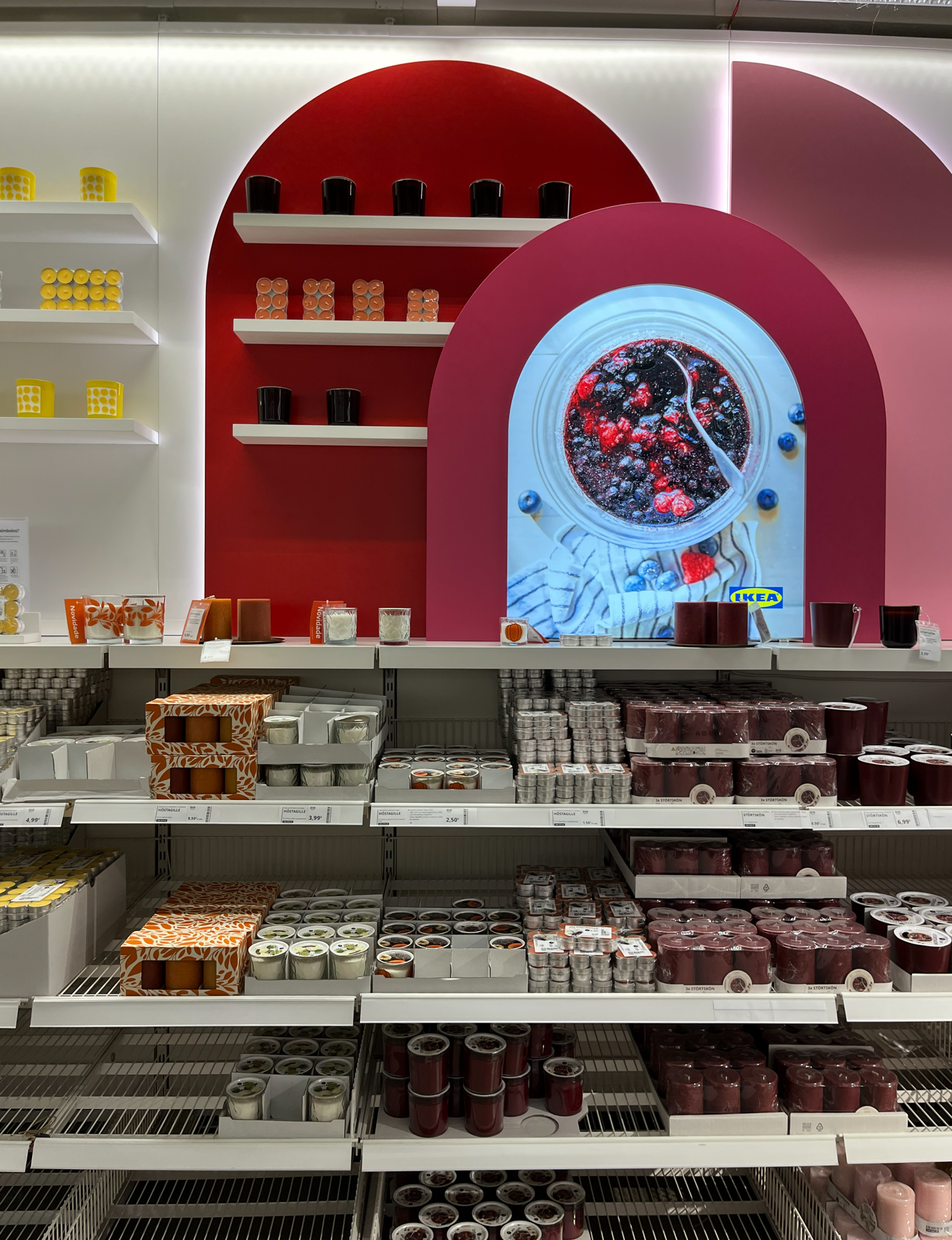 Progressive pricing strategy in IKEA candle display with entry products near aisle and premium items deeper in wall