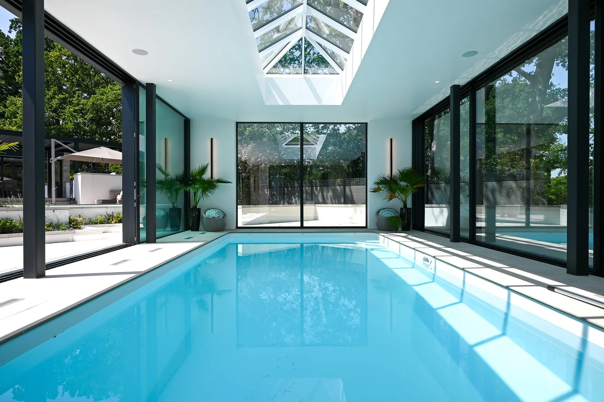inside pool house with indoor pool and large skylight