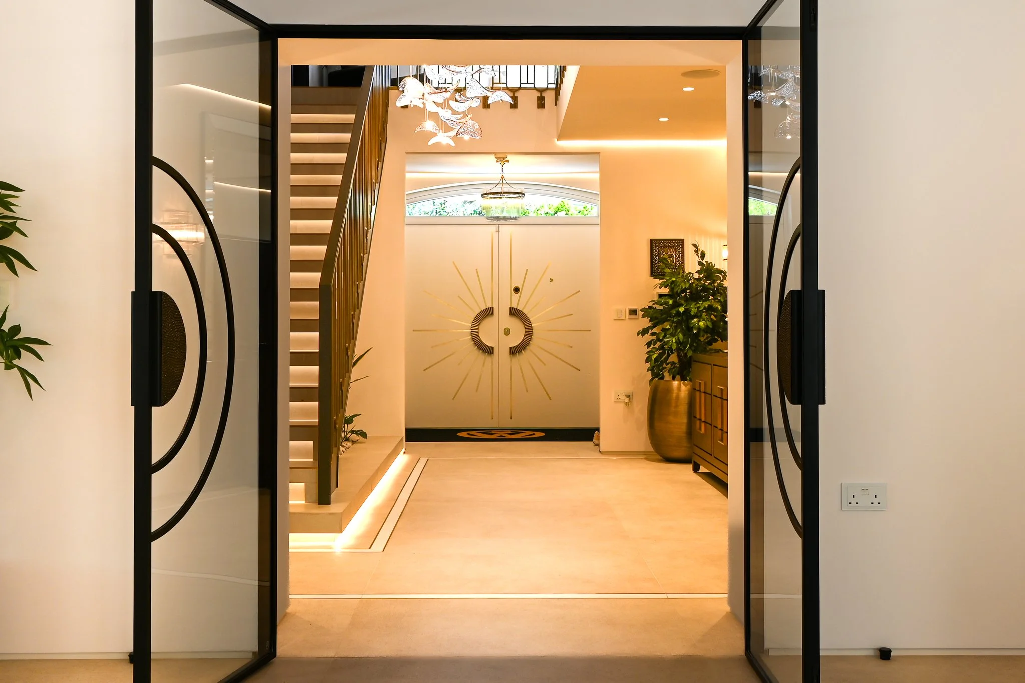 open plan hallway with double doors and stone flooring leading from the front door to living area