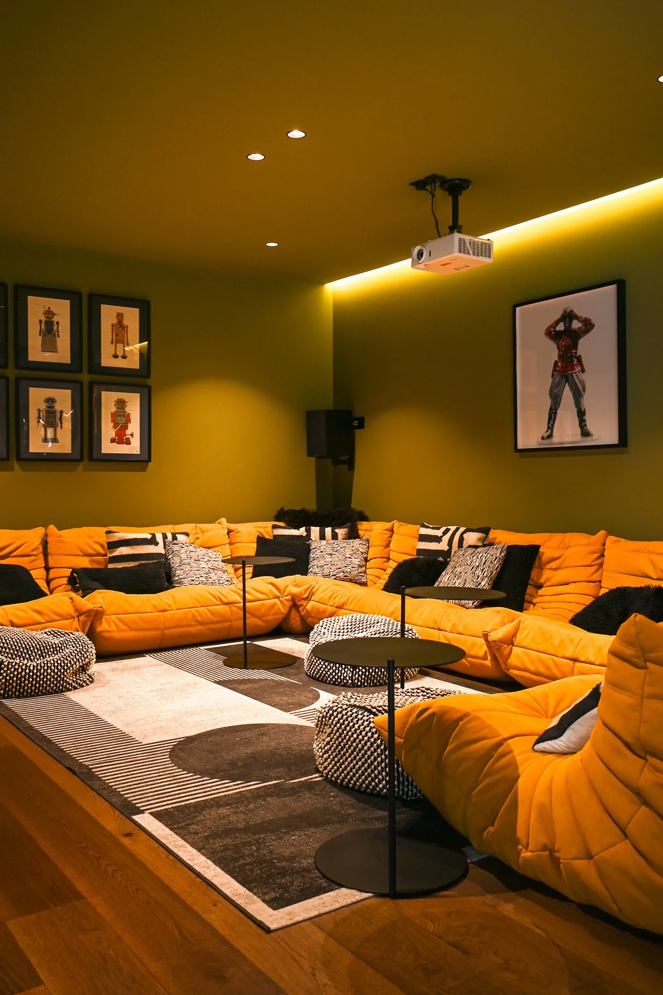 corner sofa in a home cinema with projector on ceiling and large rug