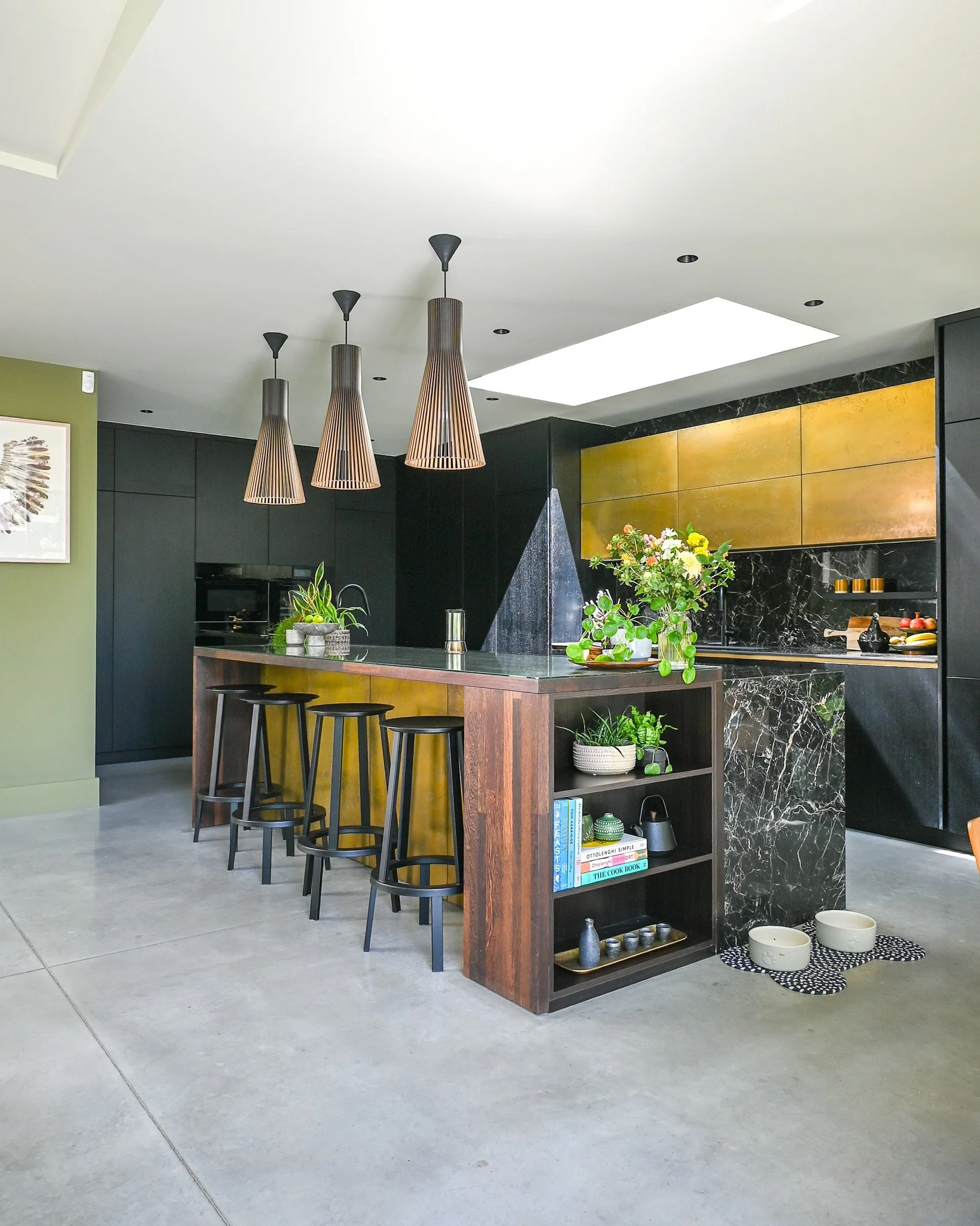 black and gold kitchen with polished concrete floor and marble worktop