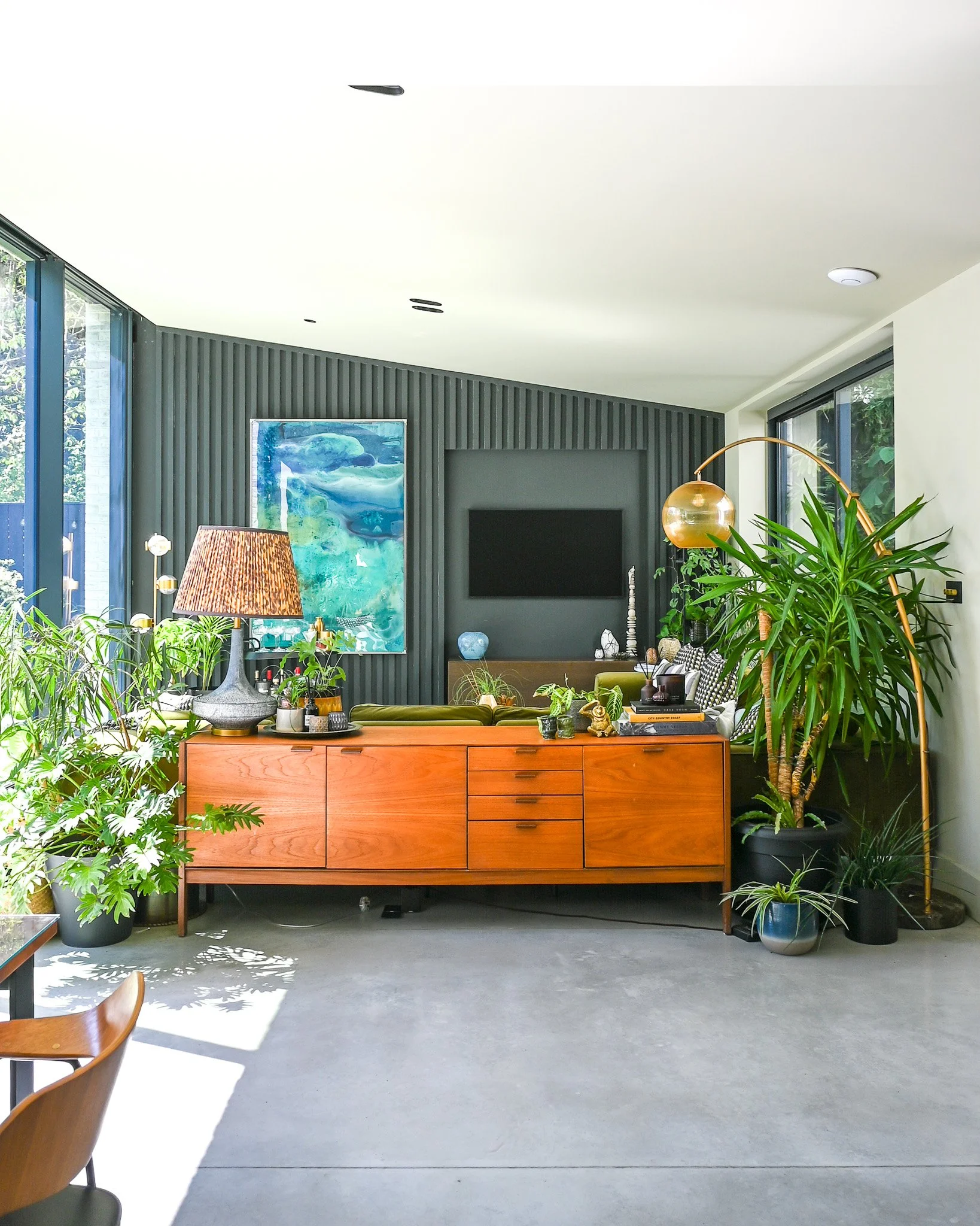 living room area with polished concrete floor with mid century furniture and tv