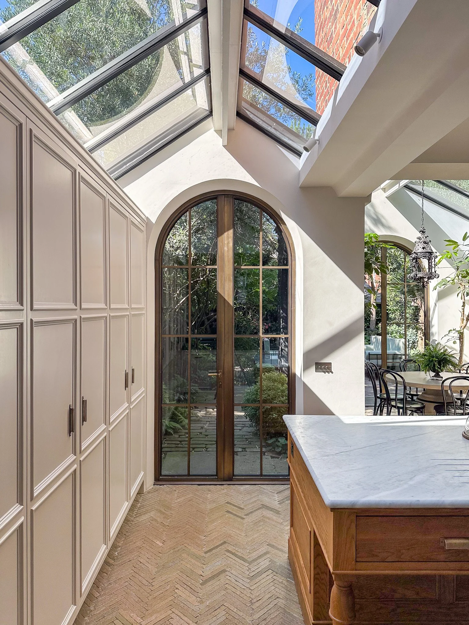 arched windows with roof lights, showing the kitchen cabinets and a marble island