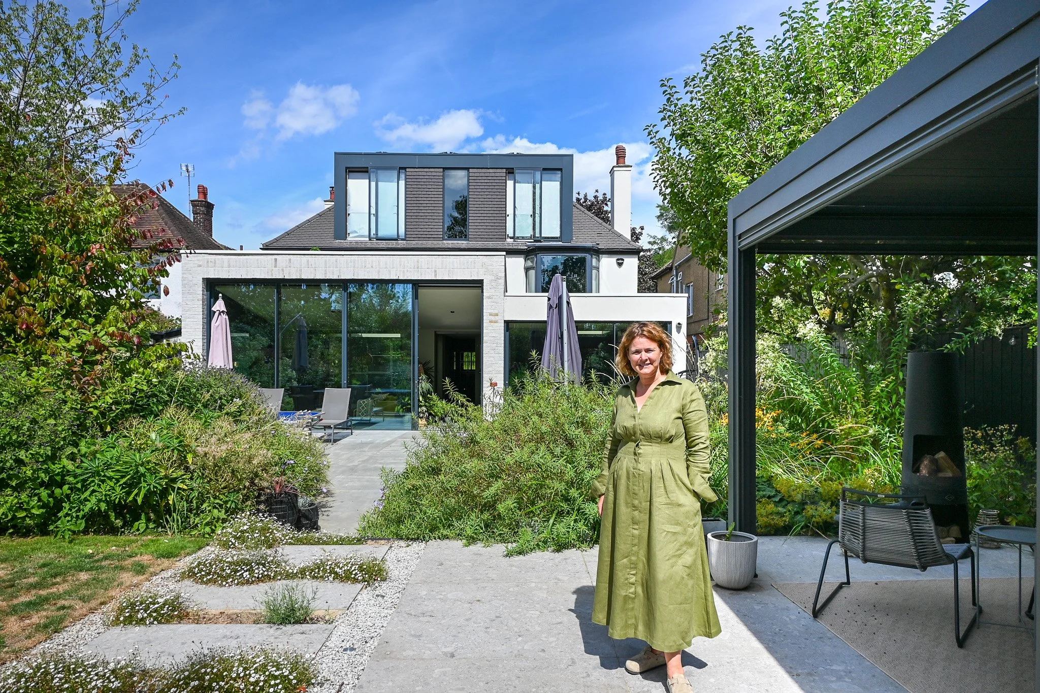 women standing in front of a detached property in north london with hedges and concrete paving