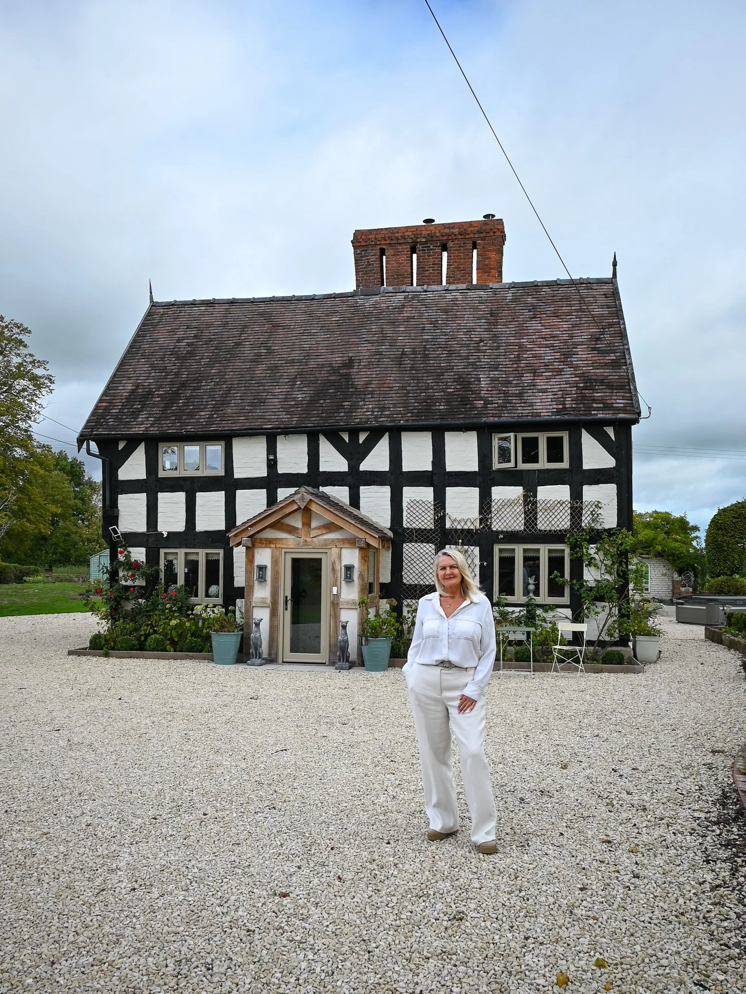 women standing in front of grade 2 listed cottage on driveway