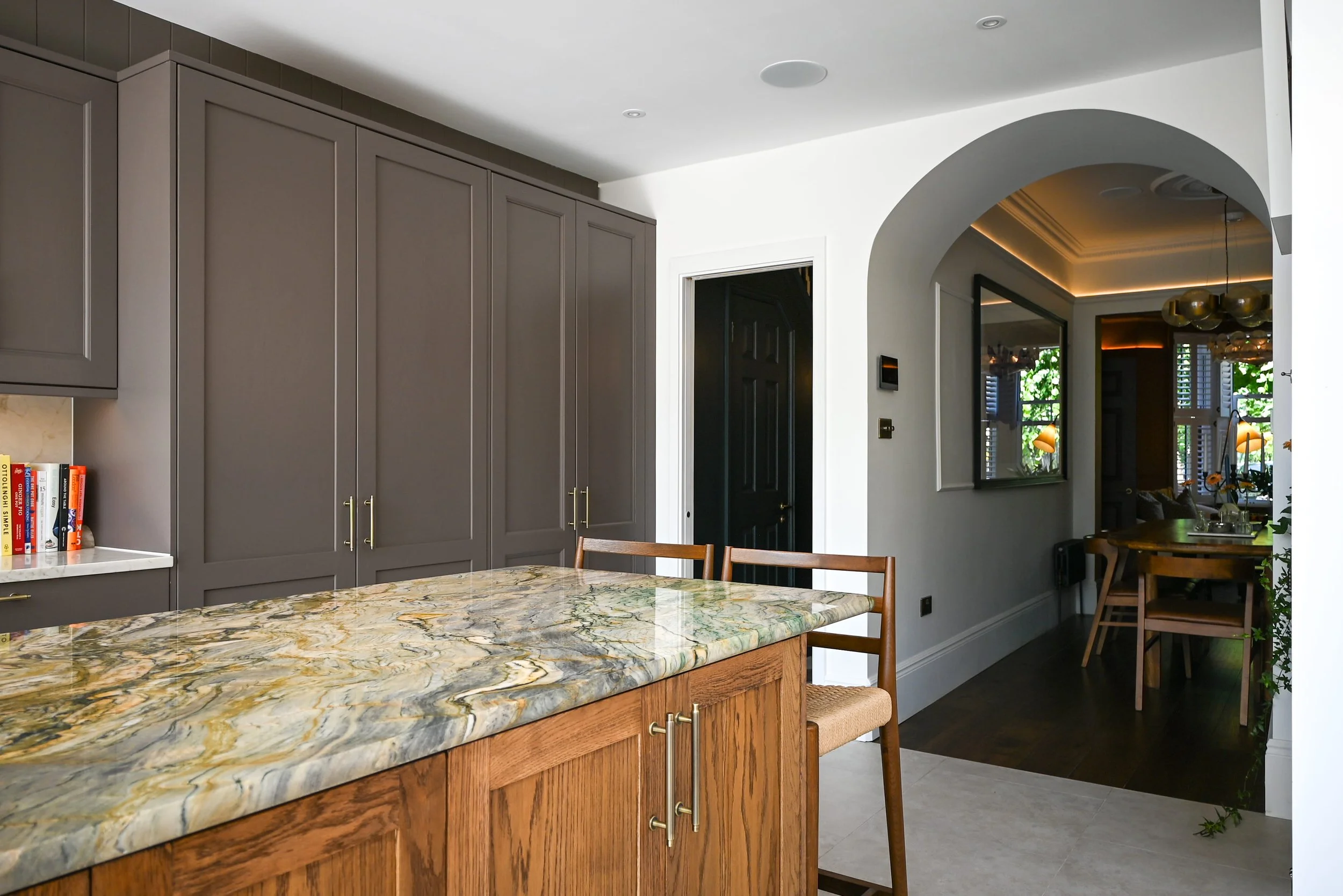 rear kitchen extension, with a large marble island and wooden doors, with an archway into the dining room
