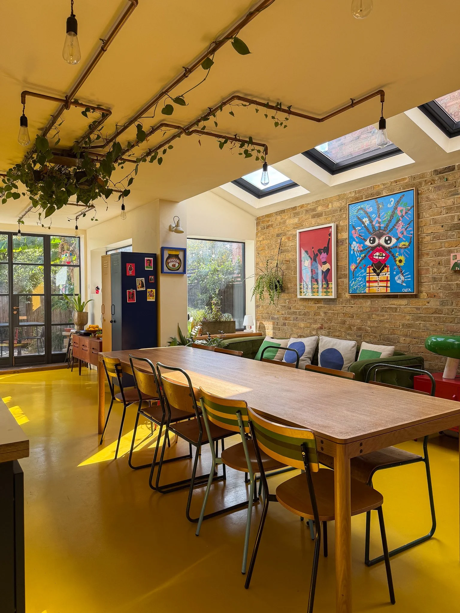 large open plan kitchen with large rooflights, double doors, dining table and yellow flooring