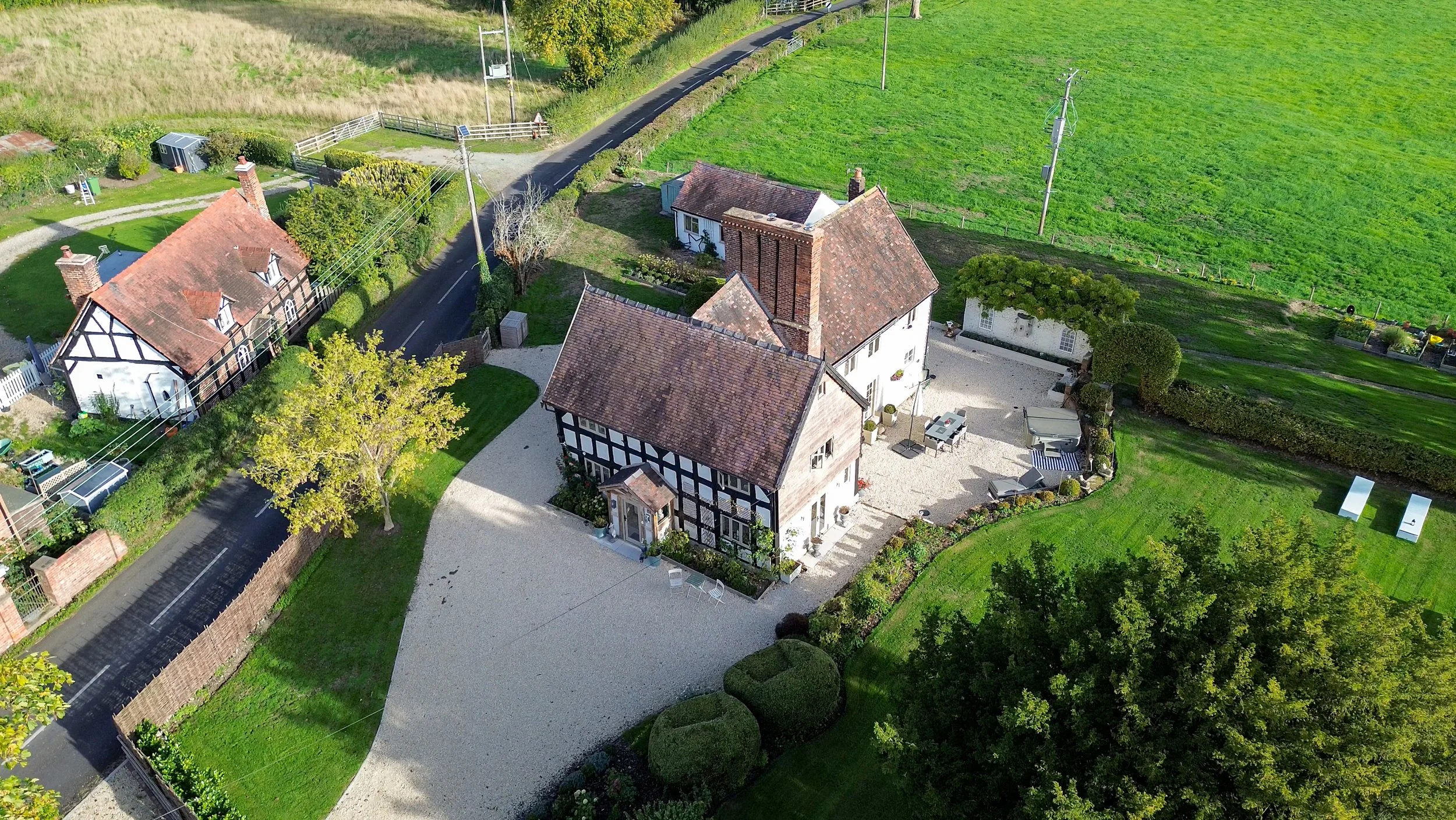 aerial shot of grade 2 listed cottage within the grounds with a large driveway and garden