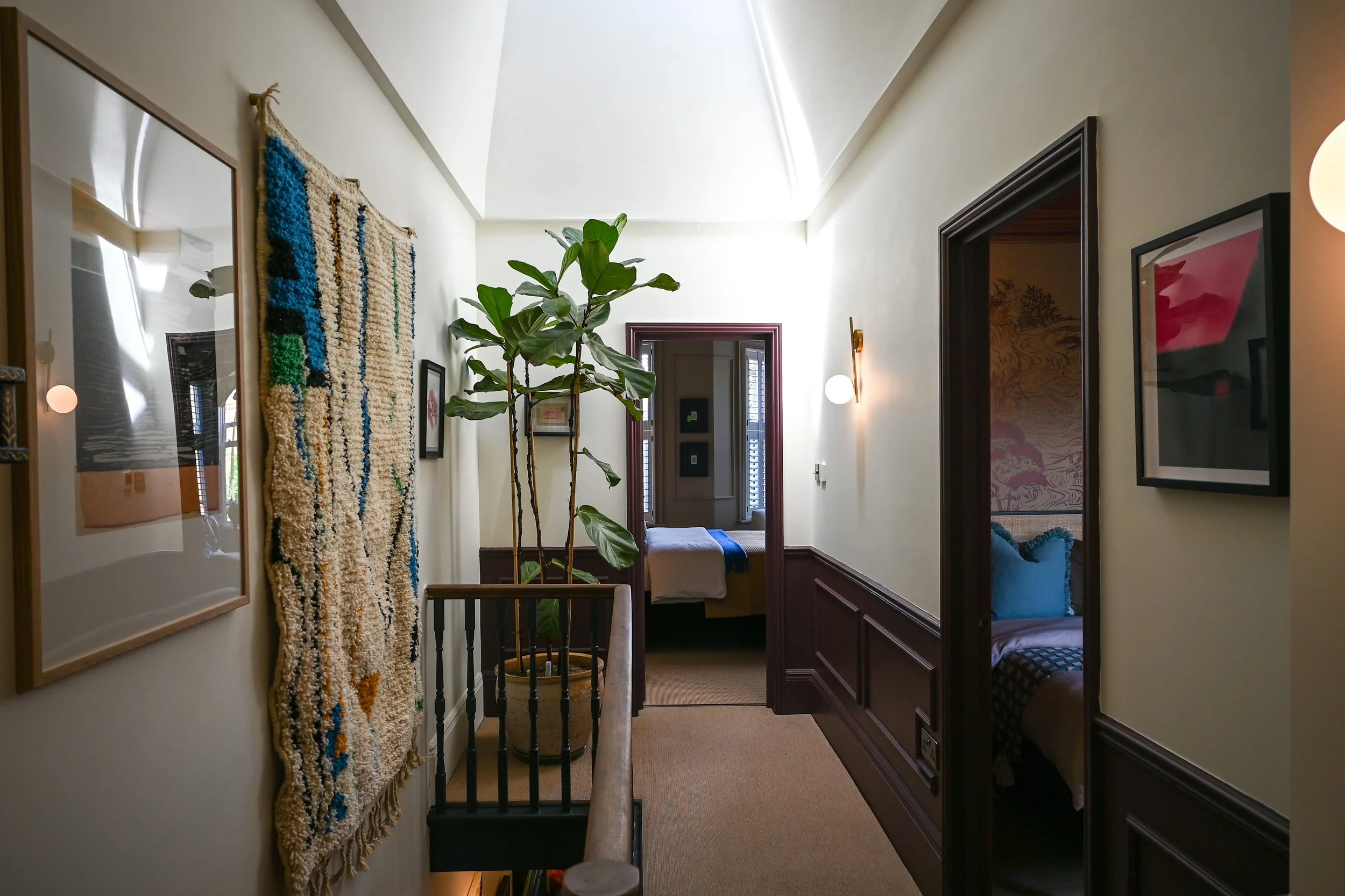 hallway with a double height space and rooflight above, with artwork on the walls