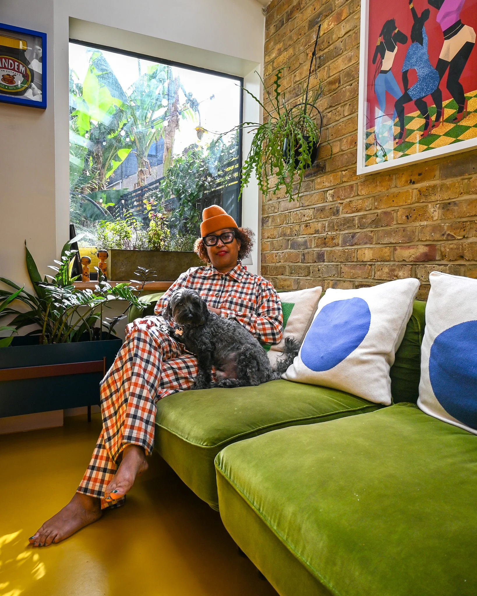 women sitting on a green sofa with her dog