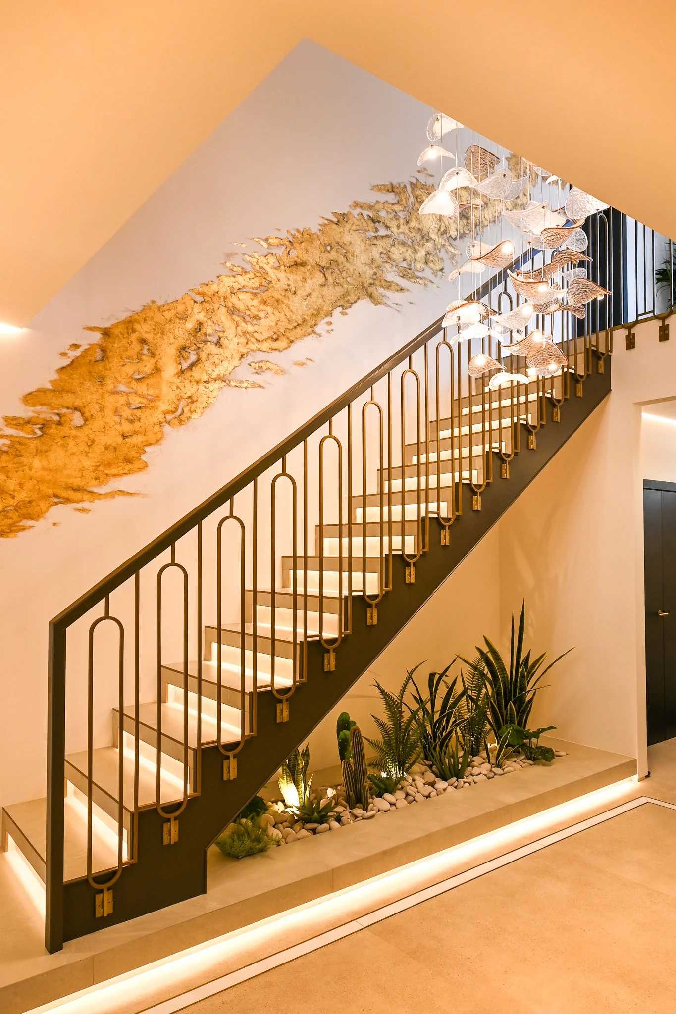 Main staircase with open treads, gold leaf decoration and strip lighting