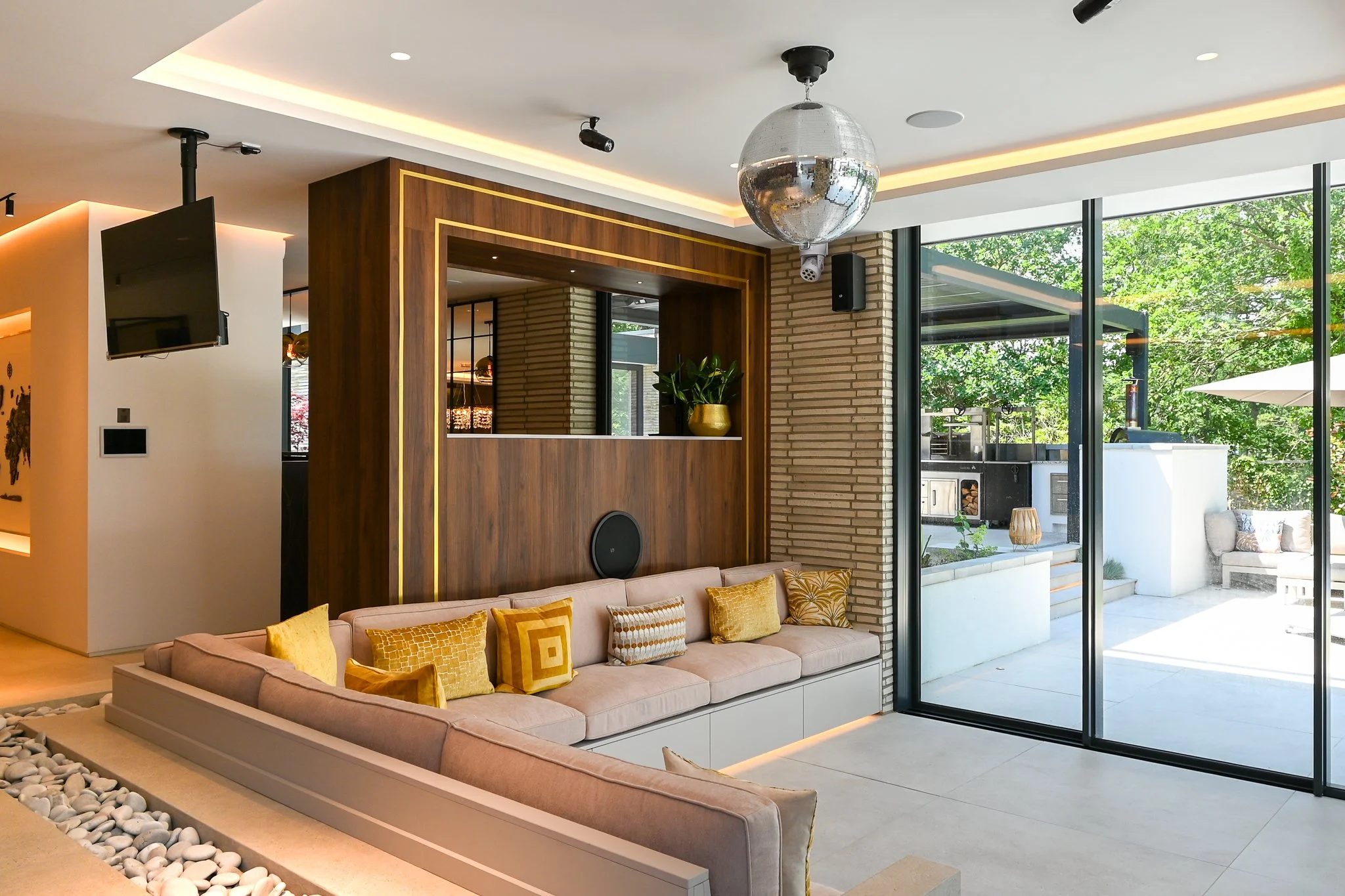sunken seating area with large bifold doors, with a bar area above