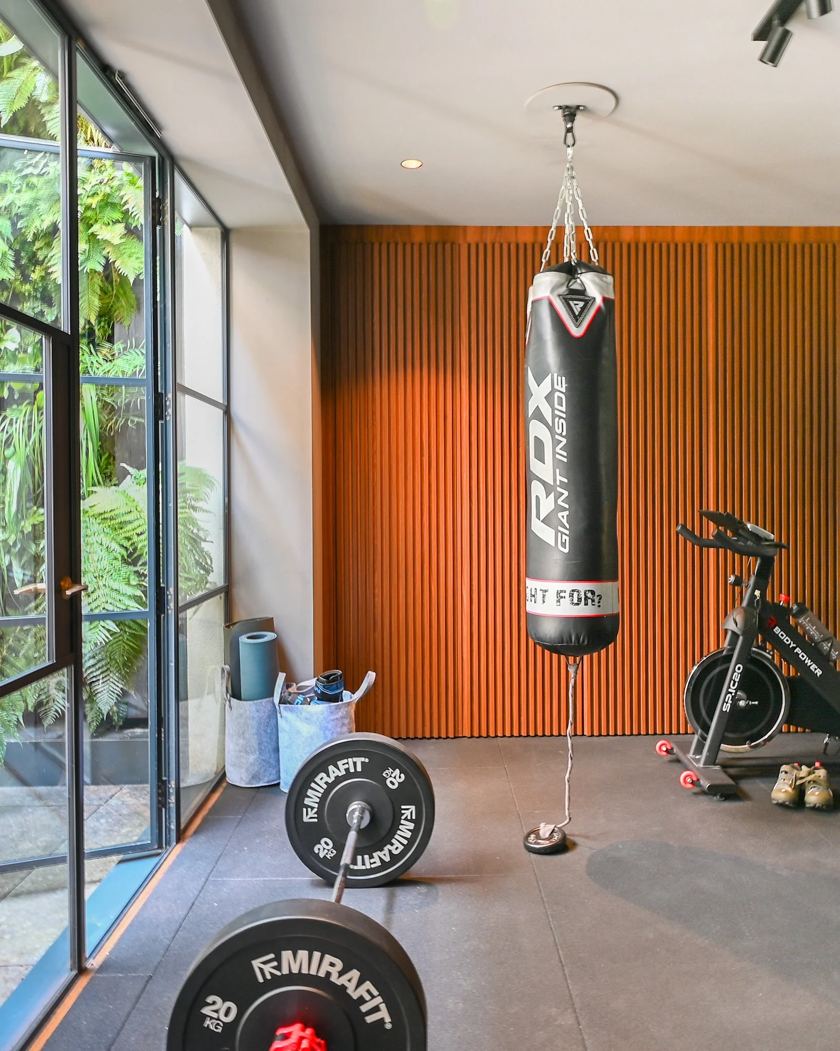 gym area with boxing bag and large glazing and timber cladding