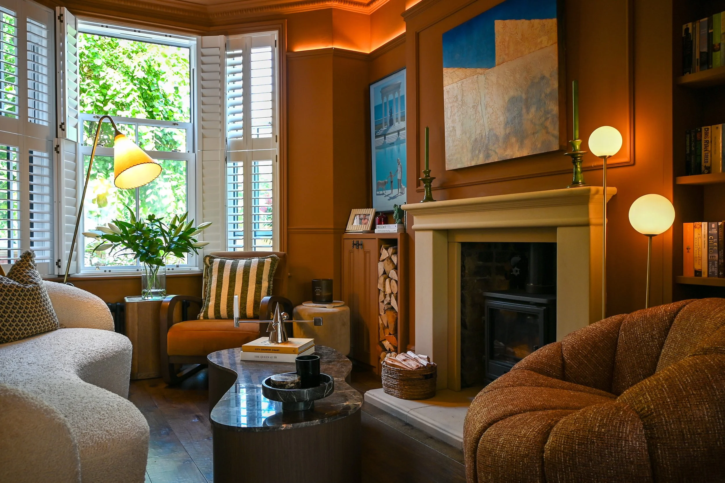 Period living room with a traditional fireplace and bay window