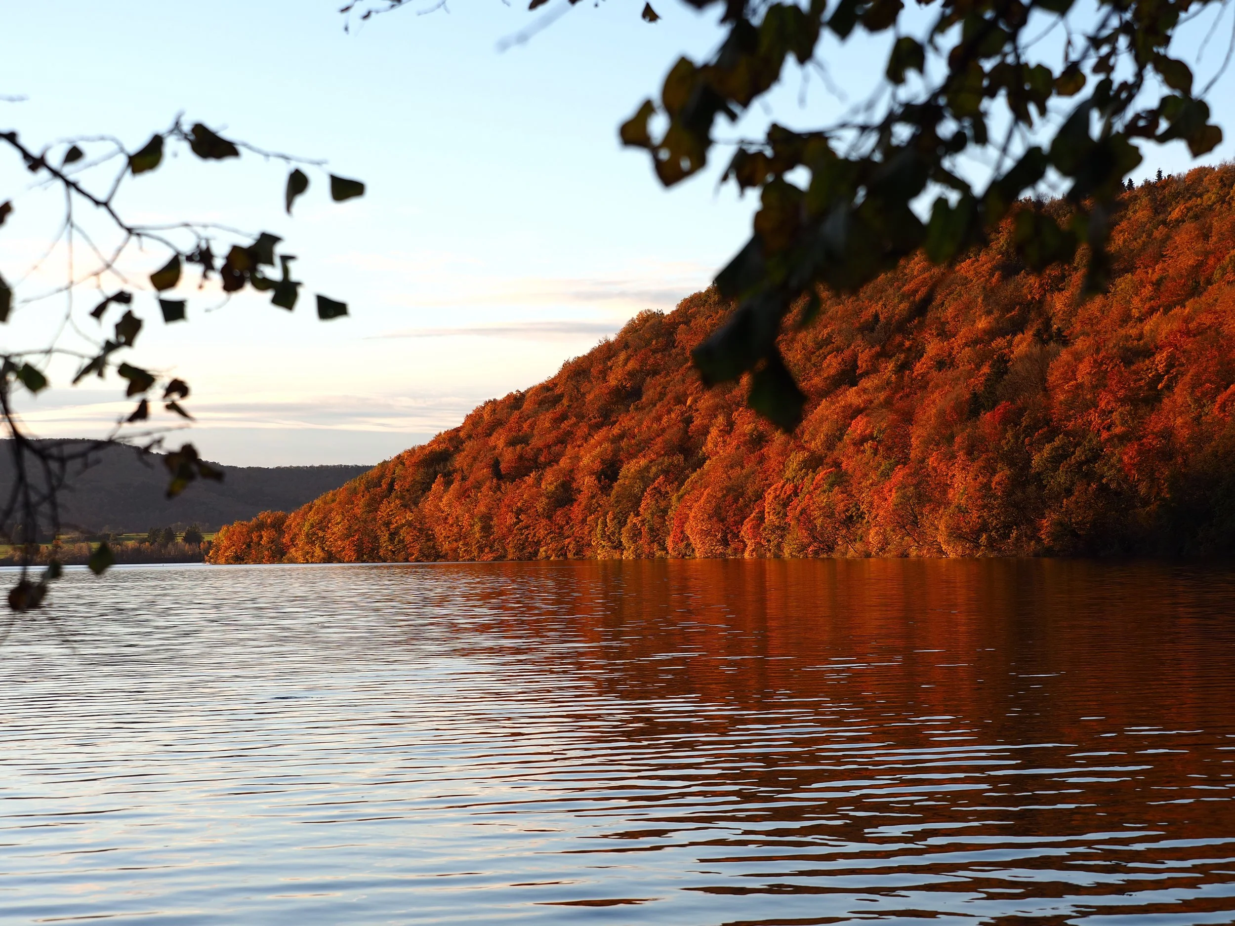 Valle automnal avec un lac calme et des arbres aux couleurs d'automne sur une colline