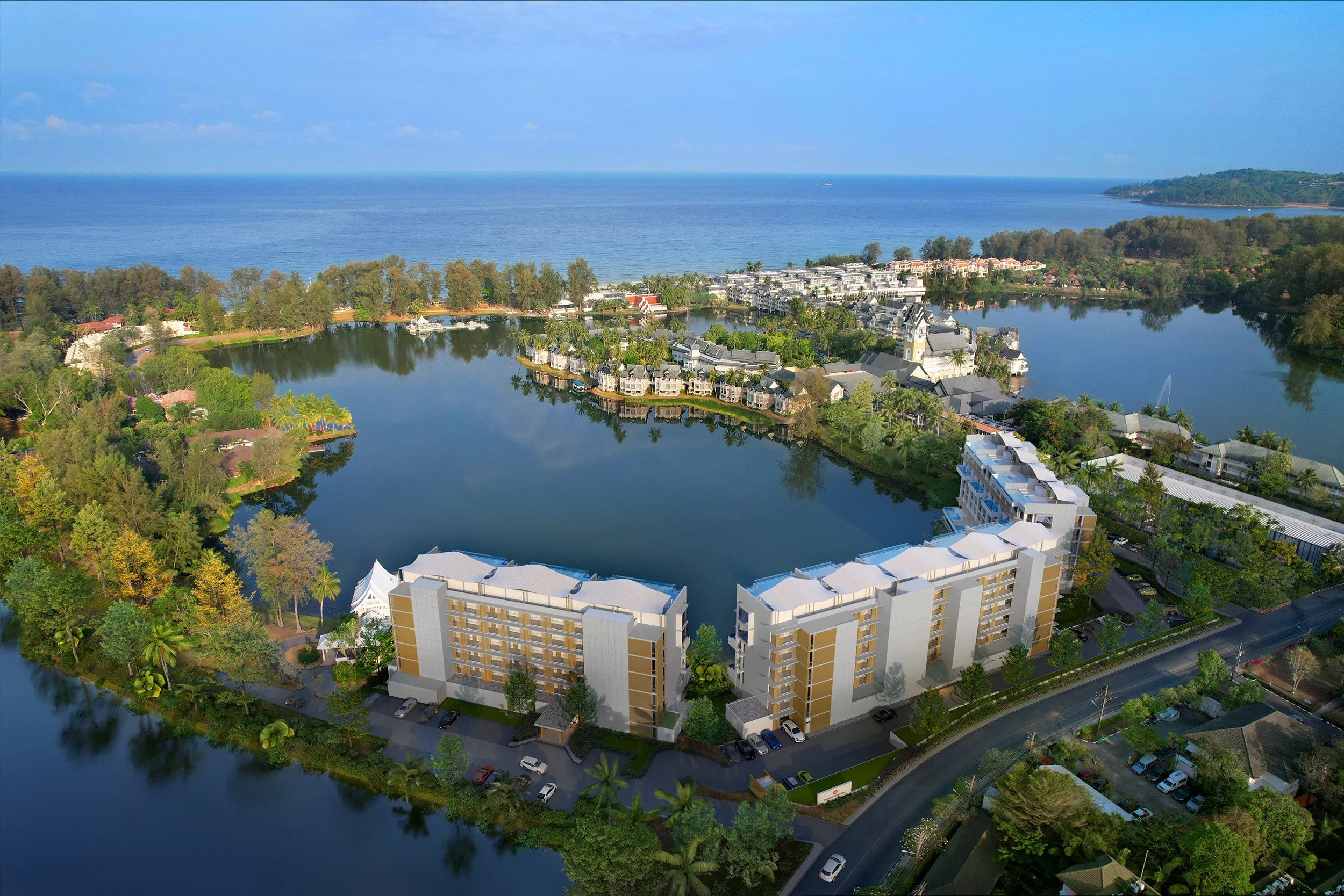 Aerial view of Angsana Oceanview Residences, a low-rise condominium development by Banyan Group curved around the lagoon in Laguna Phuket, with Bang Tao Beach and the Andaman Sea in the background