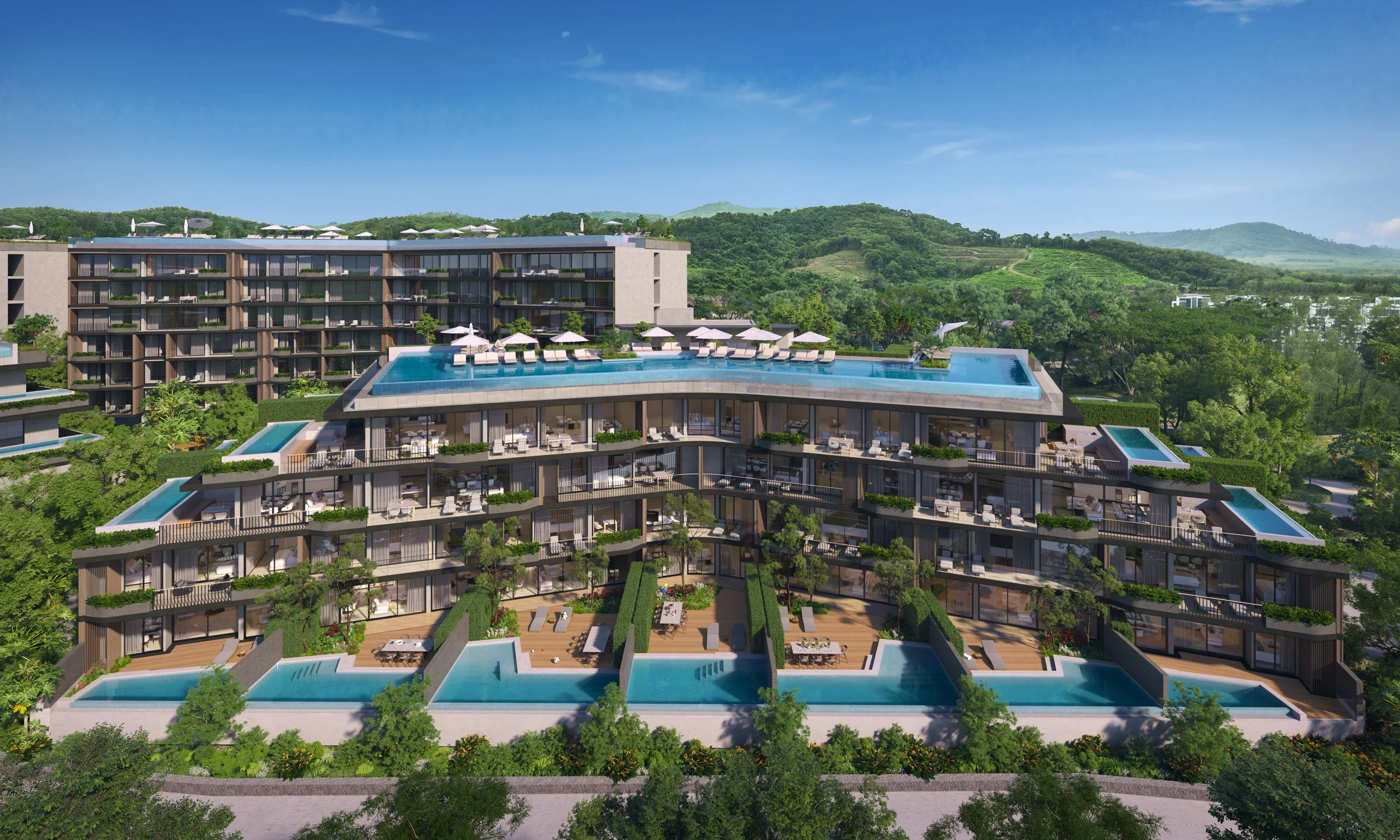 A modern multi-story residential building with multiple swimming pools and outdoor lounging areas surrounded by lush green trees and hills in the background.