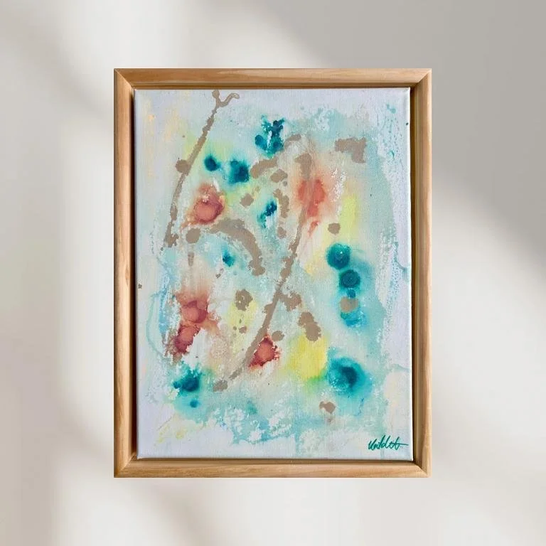 Abstraktes Wasserfarbenbild mit bunten Flecken in Rot, Blau, Gelb und Grau, in einem Holzrahmen