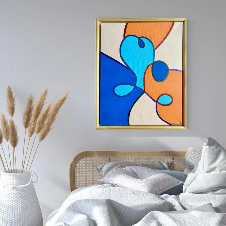 Ein Schlafzimmer mit einem Bett, Laken und Kissen, einem weißen Korb mit Pampasgras, und einem bunten abstrakten Kunstwerk an der Wand.