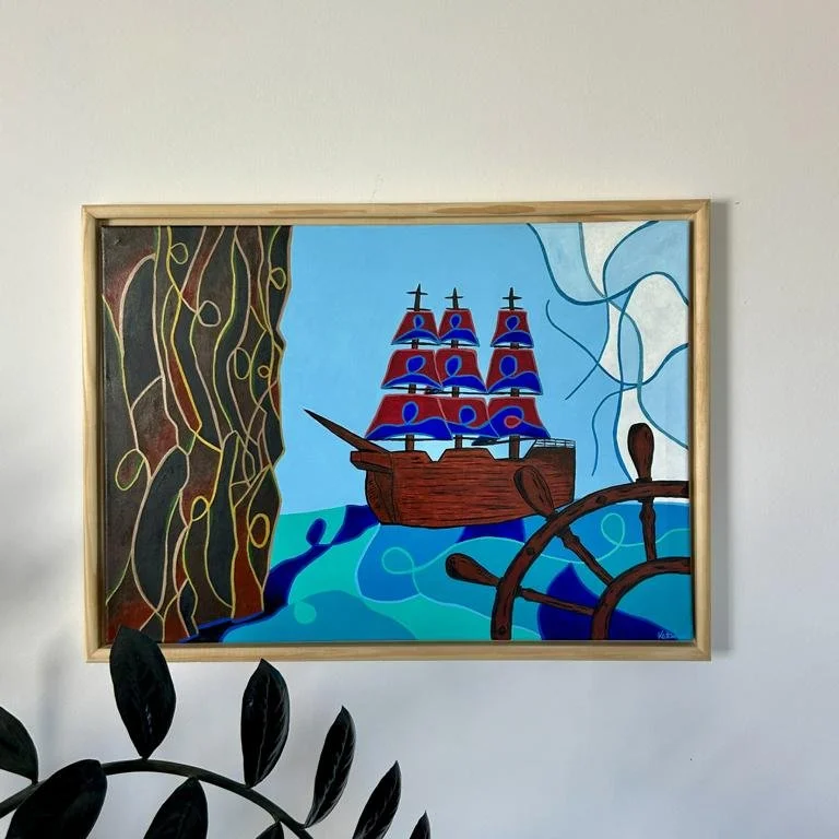 Ein Gemälde eines Piratenschiffs mit drei Masten auf hoher See, umgeben von Wasser, Felsen und Himmel, in einem Holzrahmen aufgehängt an einer weißen Wand.