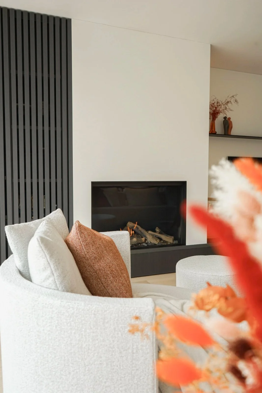 Woonkamer met zithoek en gashaard, ingericht door Atelier Ombre in een nieuwbouwwoning in Destelbergen