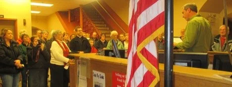 Shelby County Right to Life Candlelight Vigil for remembering the Unborn and Aborted; People standing in line at a counter with an American flag in the foreground.