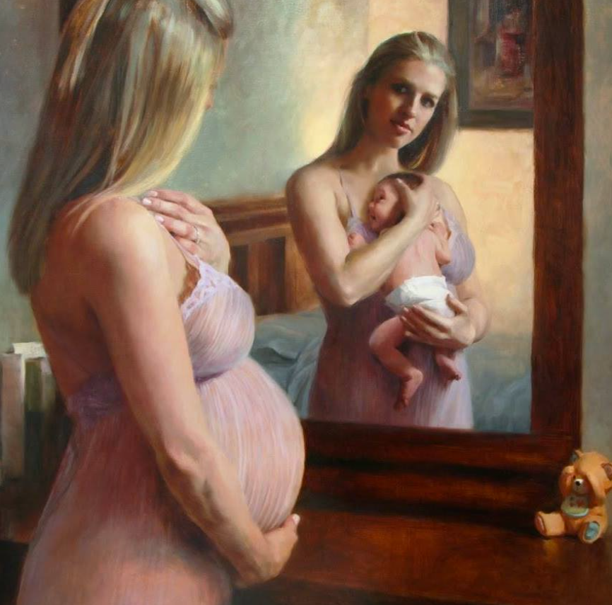 A pregnant woman looking at her reflection in a mirror, holding her pregnant belly, while her reflection shows her holding a baby. The woman has long blonde hair and is wearing a pink dress. There is a teddy bear on the dresser beside the mirror.