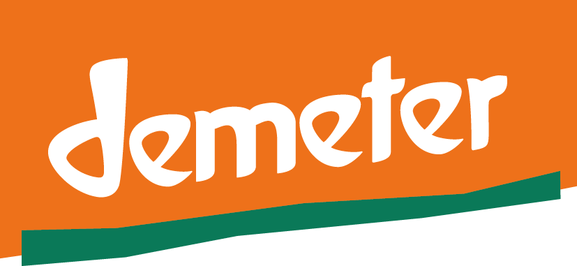 Logo mit dem Wort 'Demeter' auf orangefarbenem Hintergrund und grünem Wellenmuster am unteren Rand.