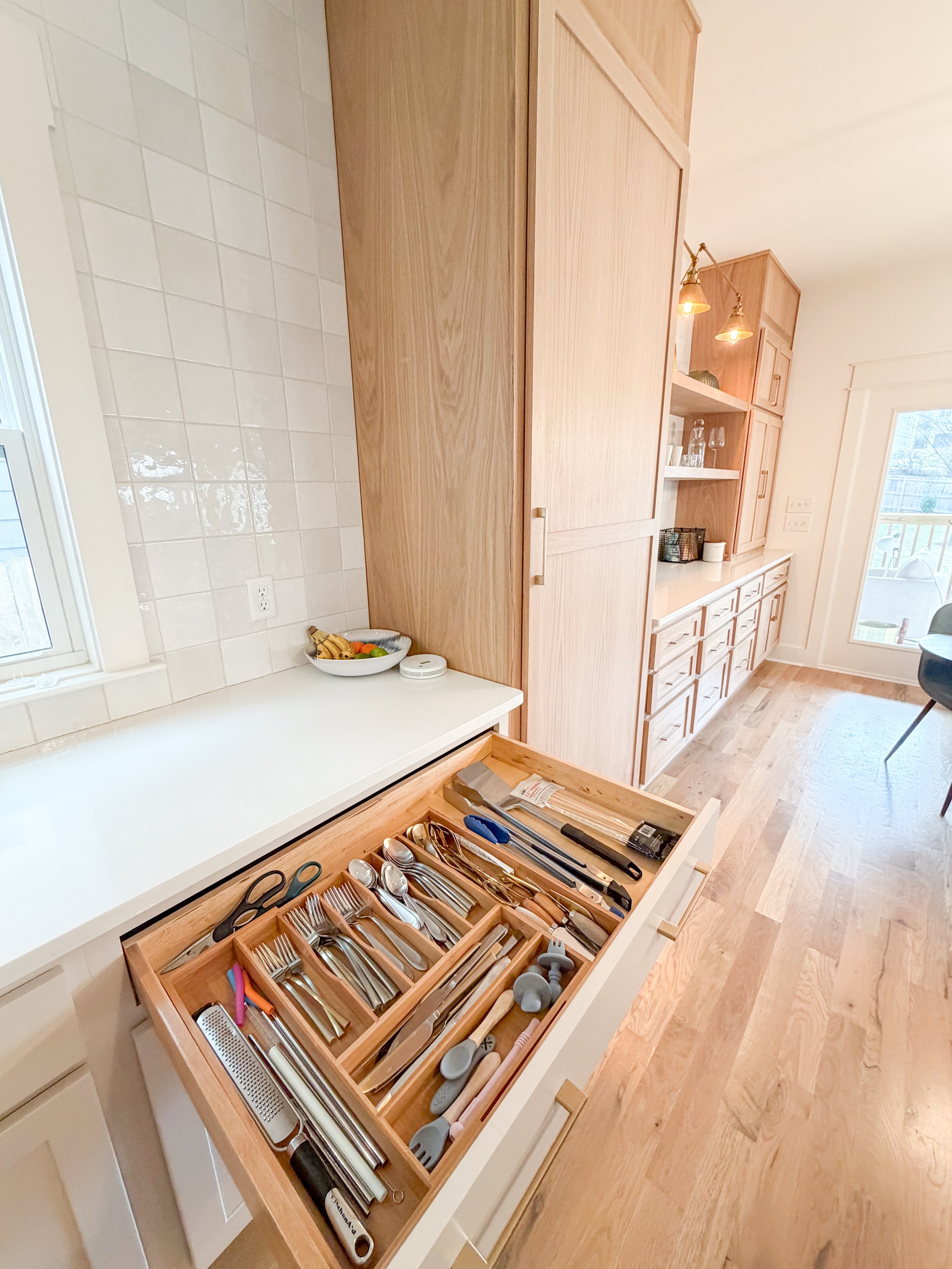 Beautiful kitchen with a highly organized utensil drawer and clean countertop