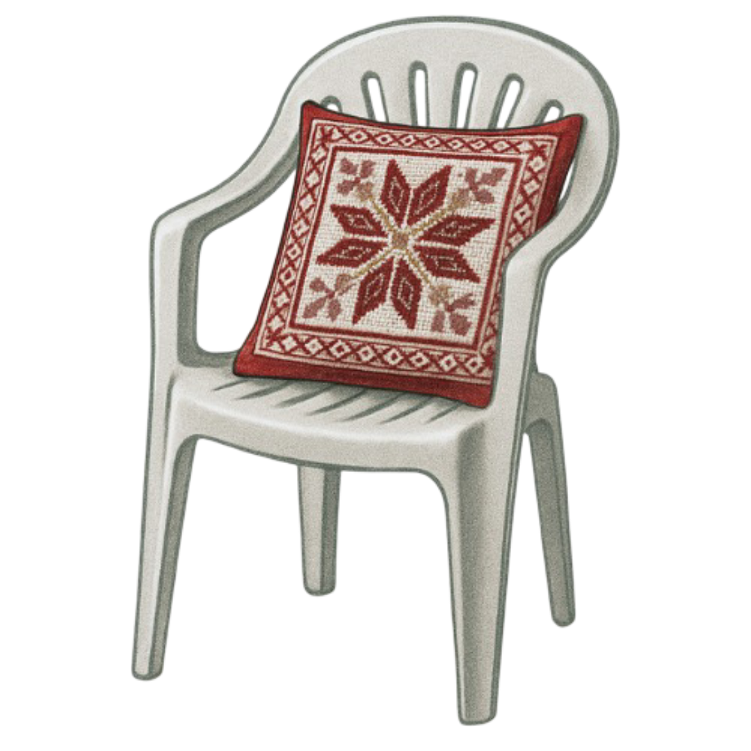 White plastic outdoor chair with a decorative red and white tatreez pillow on it.