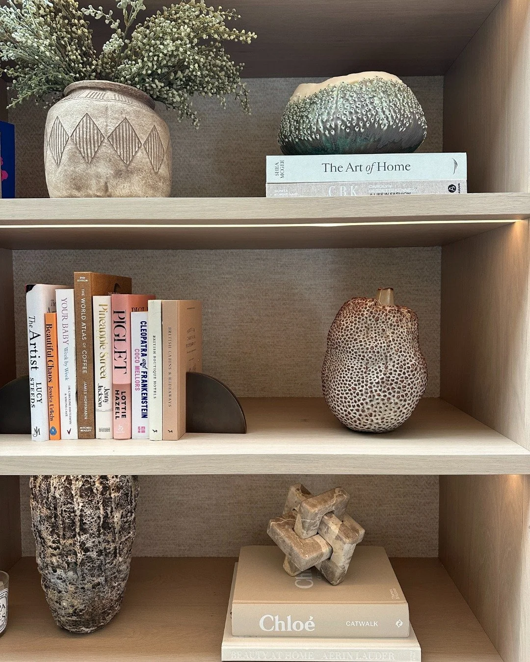 Styling a bookcase is all about balance - mixing books, art and objects in a way that feels curated yet effortless.

I like to play with vertical and horizontal stacks, layer in decorative pieces (a sculptural vase or a favourite bowl), and lean artw