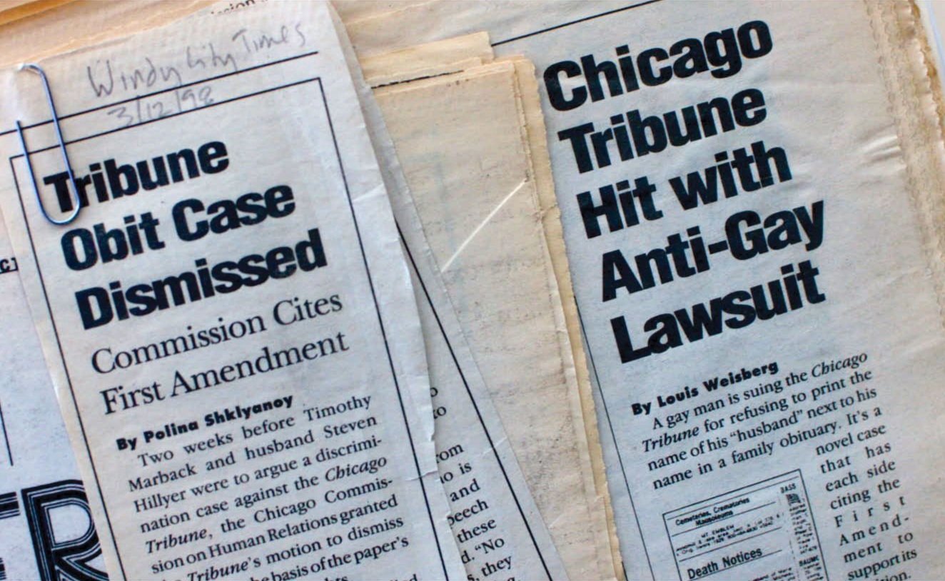 Clipping from the Chicago Tribune featuring headlines about a hit with an anti-gay lawsuit and the dismissal of a Tribune obit case, with handwritten notes on the top left corner.