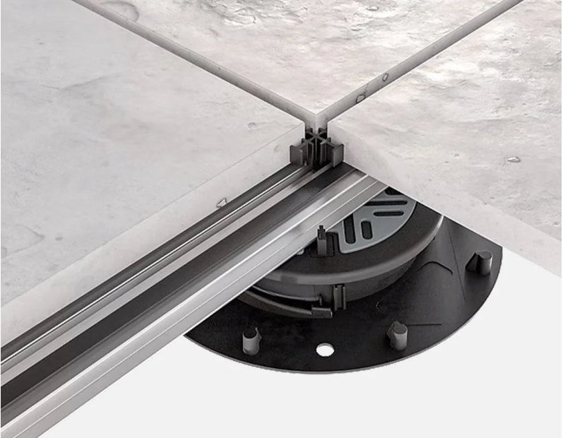 Close-up of a mechanical adjustable pedestal supporting a concrete slab.