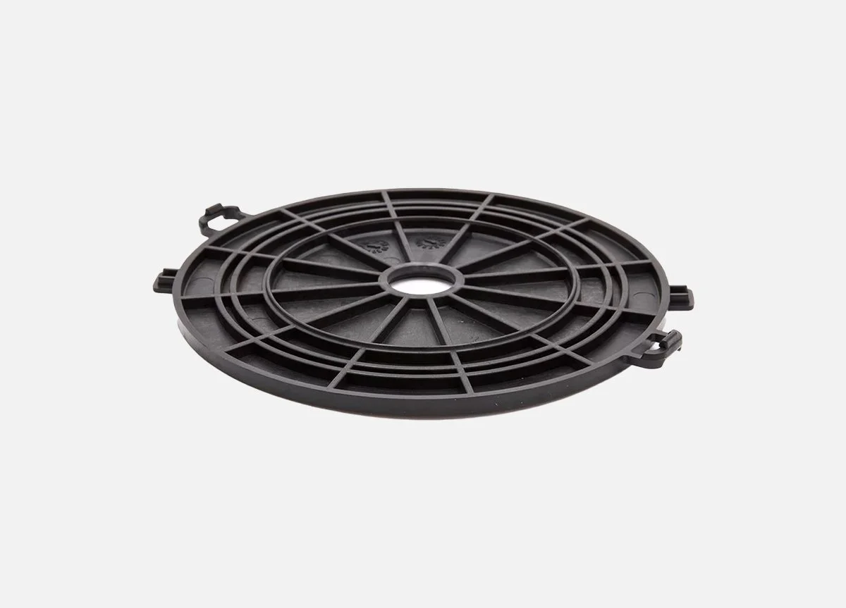 Black circular plastic component with radial spokes and a central hole, likely a cover or a grate.