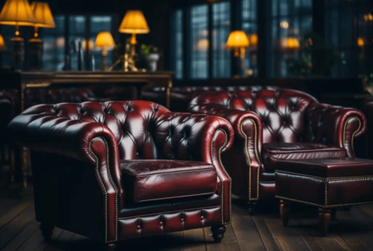 Luxurious room with dark red leather armchairs, soft lighting from table lamps, and wooden flooring.