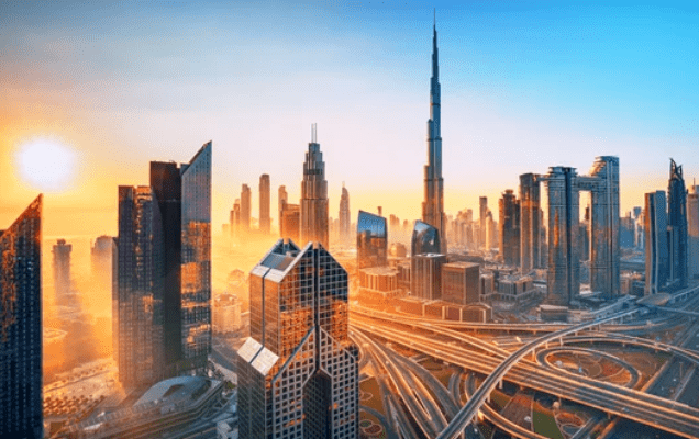City skyline at sunrise, featuring tall skyscrapers and a complex road network.