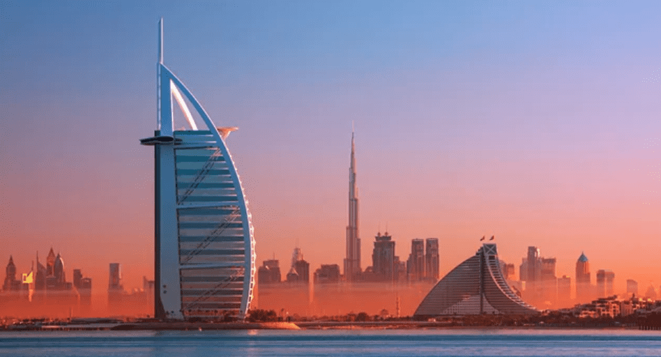 Dubai skyline with Burj Al Arab, Burj Khalifa, and cityscape at sunset.
